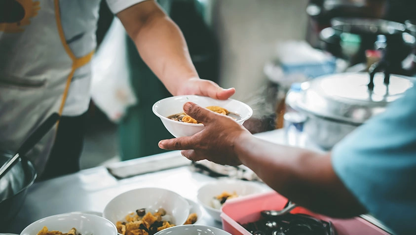 Volunteer Handing Food to Someone - Micro Accounting